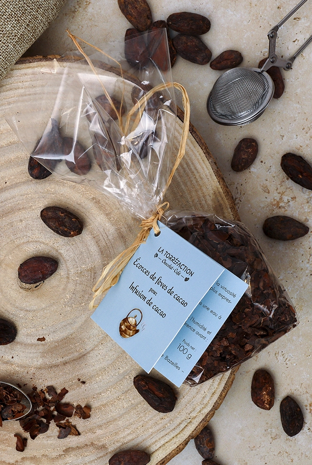 Sachet d’écorces de cacao, accessoires et fèves, vue verticale, ambiance food artisanale et branding
