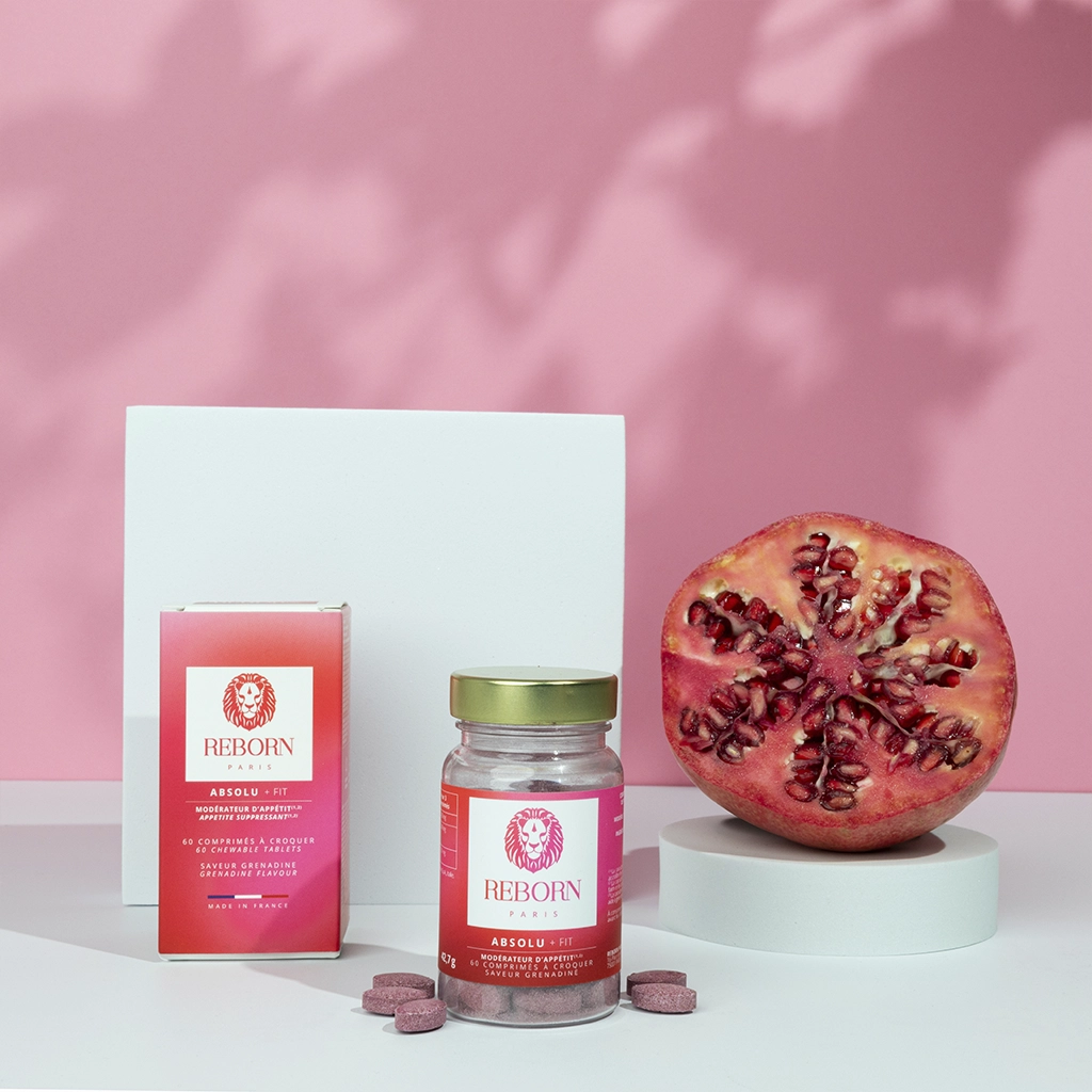 Compléments Reborn Absolu+ Fit, boîte et pot rose, grenade fraîche, fond rose doux.