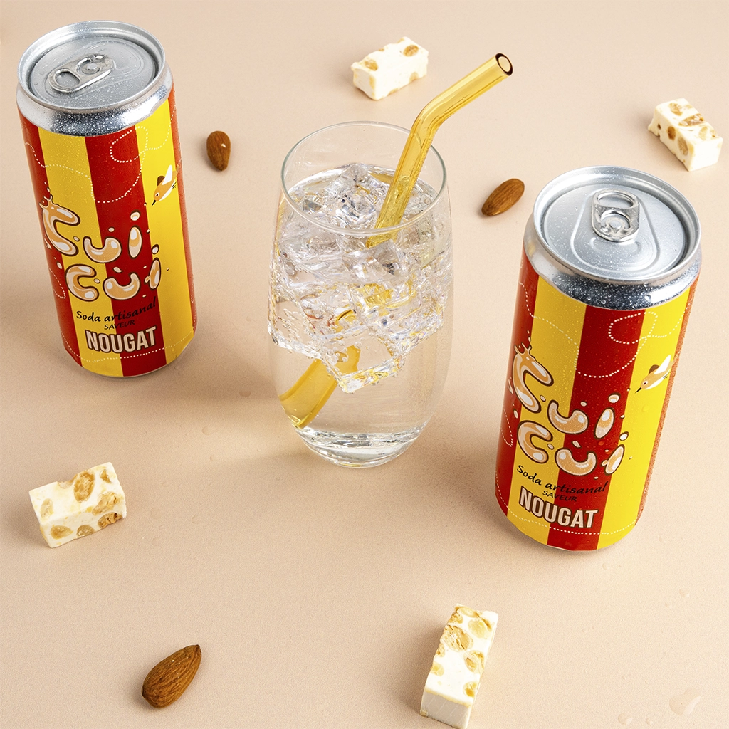 Canettes soda Cui Cui nougat avec verre glaçons, amandes et morceaux de nougat blanc.