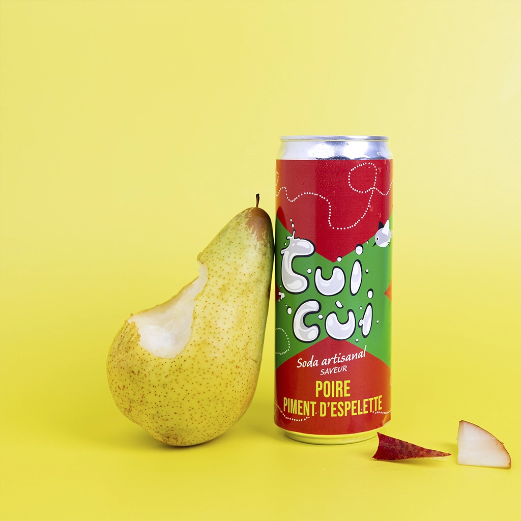 Canette soda Cui Cui poire piment d'Espelette avec poire croquée sur fond jaune vif.