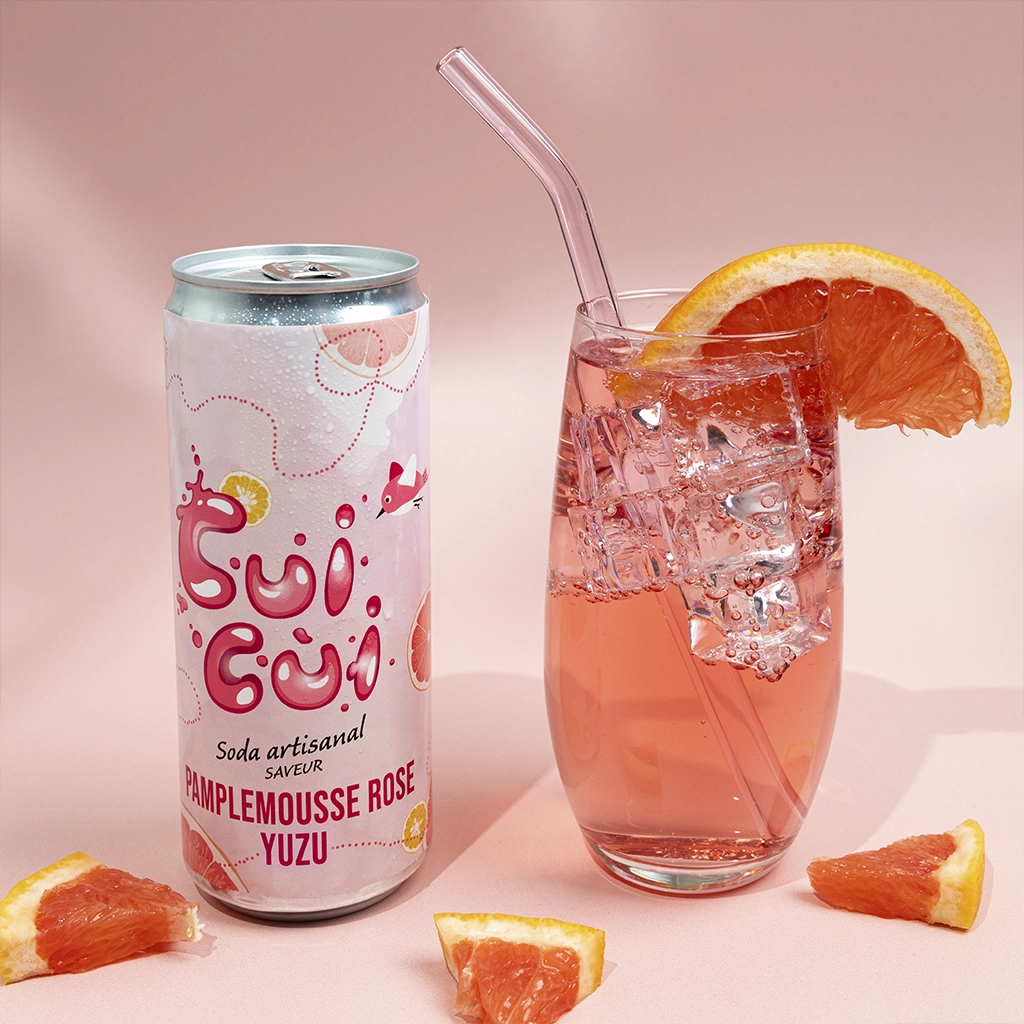 Soda Cui Cui pamplemousse rose yuzu avec verre et quartiers de pamplemousse.