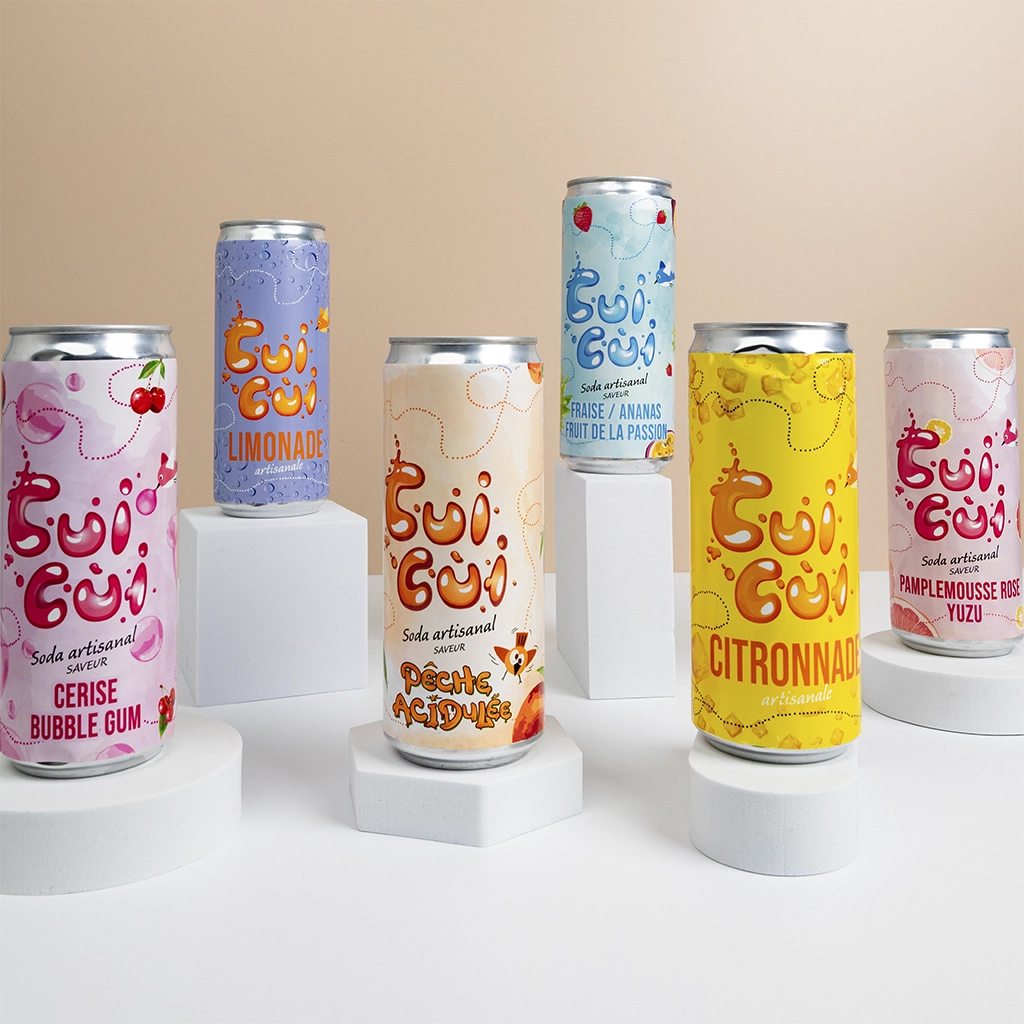 Gamme complète de canettes de sodas Cui Cui sur podiums blancs, saveurs variées.